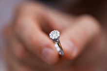 Close-up Of A Ring In A Mans Hand. Young Man Giving Engagement Ring To His Girlfriend. Man Making Marriage Proposal To His Beloved Woman. Romantic Date.