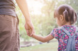 © paulaphoto - Closeup little asian girl holding her father’s hand leading on green field nature spring summer outdoor. Nature love family single dad and father’s day concept
