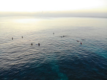 Aerial View Of Surfers On Their Board Waiting The Waves During Sunset, Big Waves Tropical Blue Ocean, Drone View Of Surfer Catching The Blue Waves, Bali, Indonesia