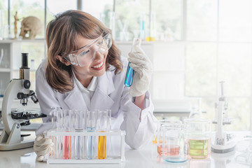 Wall Mural - a young asian woman scientist working in laboratory with test tube microscope and solutions.