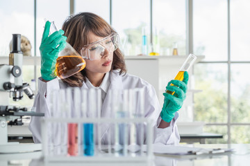 Wall Mural - a young asian woman scientist working in laboratory with test tube microscope and solutions.
