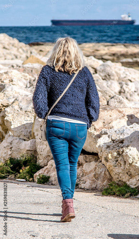Woman with big booty in jeans walking down the street Stock Photo