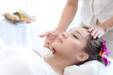 beautiful and healthy young woman relaxing with face massage  at beauty spa salon