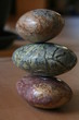 Steine in magenta, rot, grün und brauner Farbe mit verschiedenen Strukturen aufeinander liegend gestapelt 