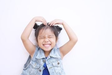 Asian child or kid girl lovely smiling and close eye make heart by arm and hand on top head or Sarang hae yo for love valentine or wedding with happy and enjoy on white background isolated with jeans