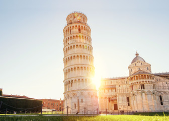 Pisa leaning tower and cathedral basilica at sunrise, Italy. Travel concept