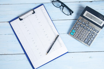 document with glasses and calculator on desk