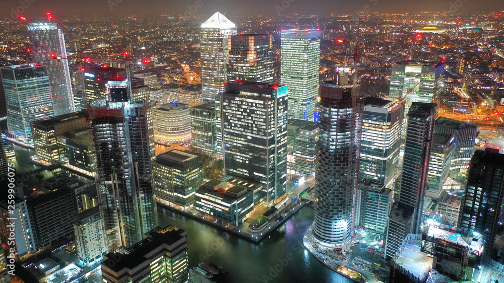 Aerial drone night shot from iconic Canary Wharf illuminated skyscrapers business and financial area, Docklands, Isle of Dogs, London, United Kingdom - obrazy, fototapety, plakaty 