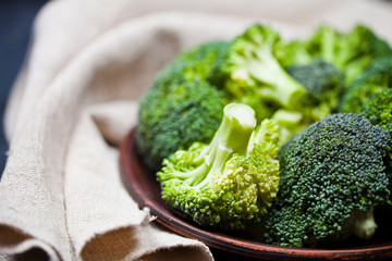 Canvas Print - Fresh green organic broccoli in brown plate and linen napkin.