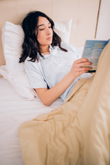 Wall Mural - Portrait pretty young girl on bed in modern apartment in the morning