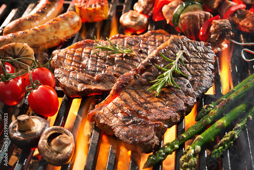 Cuadros en Lienzo Delicious grilled meat with vegetables sizzling over the coals on barbecue