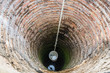 Plastic bucket in old ancient groundwater well.