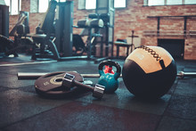 Disassembled Barbell, Medicine Ball, Kettlebell, Dumbbell Lying On Floor In Gym. Sports Equipment For Workout With Free Weight. Functional Training