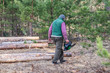 © Taras - Woodcutter with a chainsaw in hand in the forest