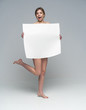 Sexy naked girl with a poster. Clean skin. Hair removed. Isolate. For advertising and presentation.