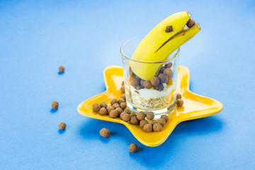 Tasty delicious banana with musli on blue background. Healthy food concept