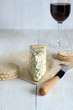 Mature Stilton cheese on aged parchment paper with crackers oat biscuits and a glass of port wine