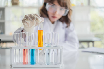Wall Mural - a young asian woman scientist working in laboratory with test tube microscope and solutions.