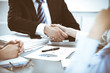 © rogerphoto - Business people shaking hands, finishing up a meeting