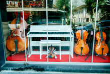 Showcase Music Store With Double Bass Violin And White Piano