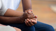 © fizkes - African american family couple holding hands, close up view