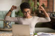 © fizkes - Excited african woman feeling winner rejoicing online win on laptop