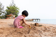 Leinwandbild Motiv Asian Chinese little girl playing sand at beach