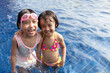 Leinwandbild Motiv Asian Little Chinese Sisters Playing in Swimming Pool
