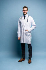 full length young medical doctor on blue background.