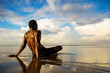 © TheVisualsYouNeed - young attractive and relaxed black afro American man with fit body and muscular back sitting on beach sand enjoying beautiful view thinking and meditating free