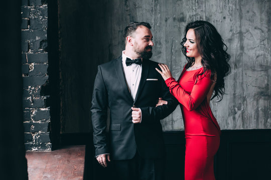 Portrait of the bride and groom. Red dress and black suit.