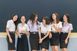 © kwanchaichaiudom - Happy teen students standing together in classroom