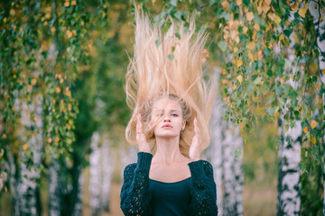 An attractive girl with fluttering long hair walks in the Park.