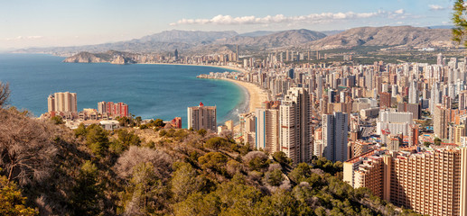 Benidorm, Costa Blanca - a coastal town and popular touristic resort in province of Alicante, Spain. View of city skyline formed by tall hotels and apartment buildings and mountains