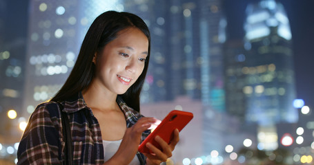 Woman use of mobile phone in city at night