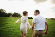 © Olha - Cute gentle couple walking in the green meadow. Young loving family enjoying spring time
