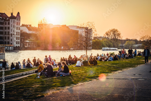 Fotomural People enjoying sunset at river next to the Berlin Wall / East Side Gallery in
