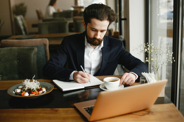 Poster - Handsome man in a black suit. Businessman working in a office