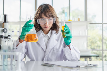 Wall Mural - a young asian woman scientist working in laboratory with test tube microscope and solutions.