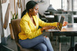 © prostooleh - Elegant black woman. Lady in a yellow jacket. Businesswoman working in a office