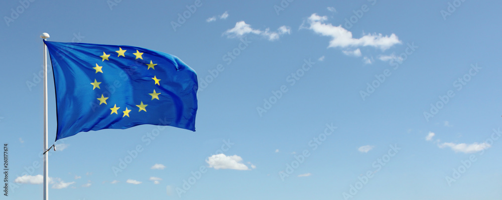 EU flag waving against blue sky with clouds. Copy space - obrazy, fototapety, plakaty 