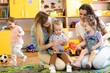 Mothers with their babies play toys in nursery
