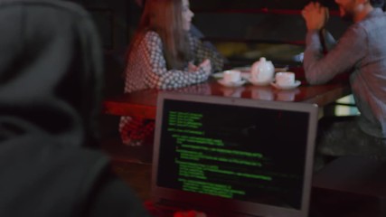 Wall Mural - rare view of young man sitting in bar at laptop and developing new software while people on backgrou