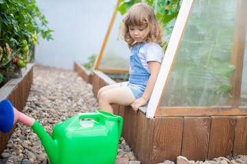 adorable girl watering plants in the garden
