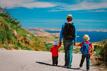 father with son and daughter walking on scenic road