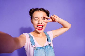 Canvas Print - Close up photo beautiful amazing she her lady two buns make take selfies show v-sign symbol near eye tongue out mouth wear casual t-shirt jeans denim overalls clothes isolated purple violet background