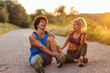© Dusan Petkovic - Fit cute couple sitting on the country road and resting from running. Man tying shoelace. Summer time in the morning.