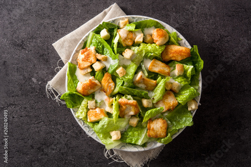 Cuadros en Lienzo Caesar salad with lettuce,chicken and croutons on black background