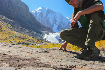 Dry tree on the background of the departed lake maashey in July 2012 and snow-white peaks