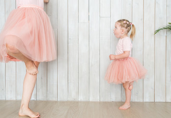 Wall Mural - Mom with her daughter in the same clothes on a white background.